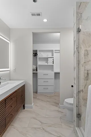 a bathroom with a granite countertop sink toilet and shower