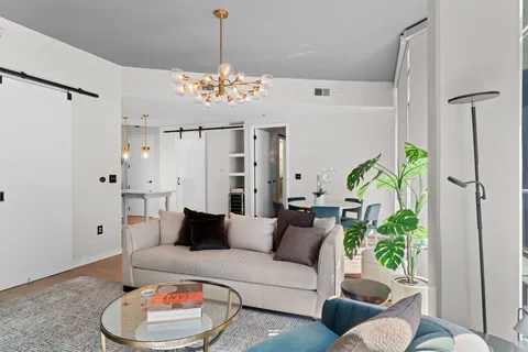 a living room with furniture and a chandelier