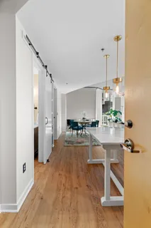 a view of a kitchen with kitchen island white cabinets and stainless steel appliances