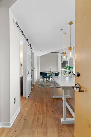 a view of a kitchen with kitchen island white cabinets and stainless steel appliances