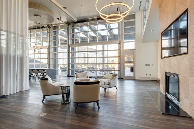 a living room with furniture a fireplace and a floor to ceiling window