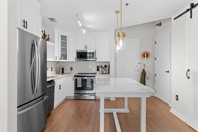a kitchen with stainless steel appliances a refrigerator sink and microwave