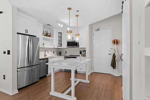 a kitchen with white cabinets and stainless steel appliances
