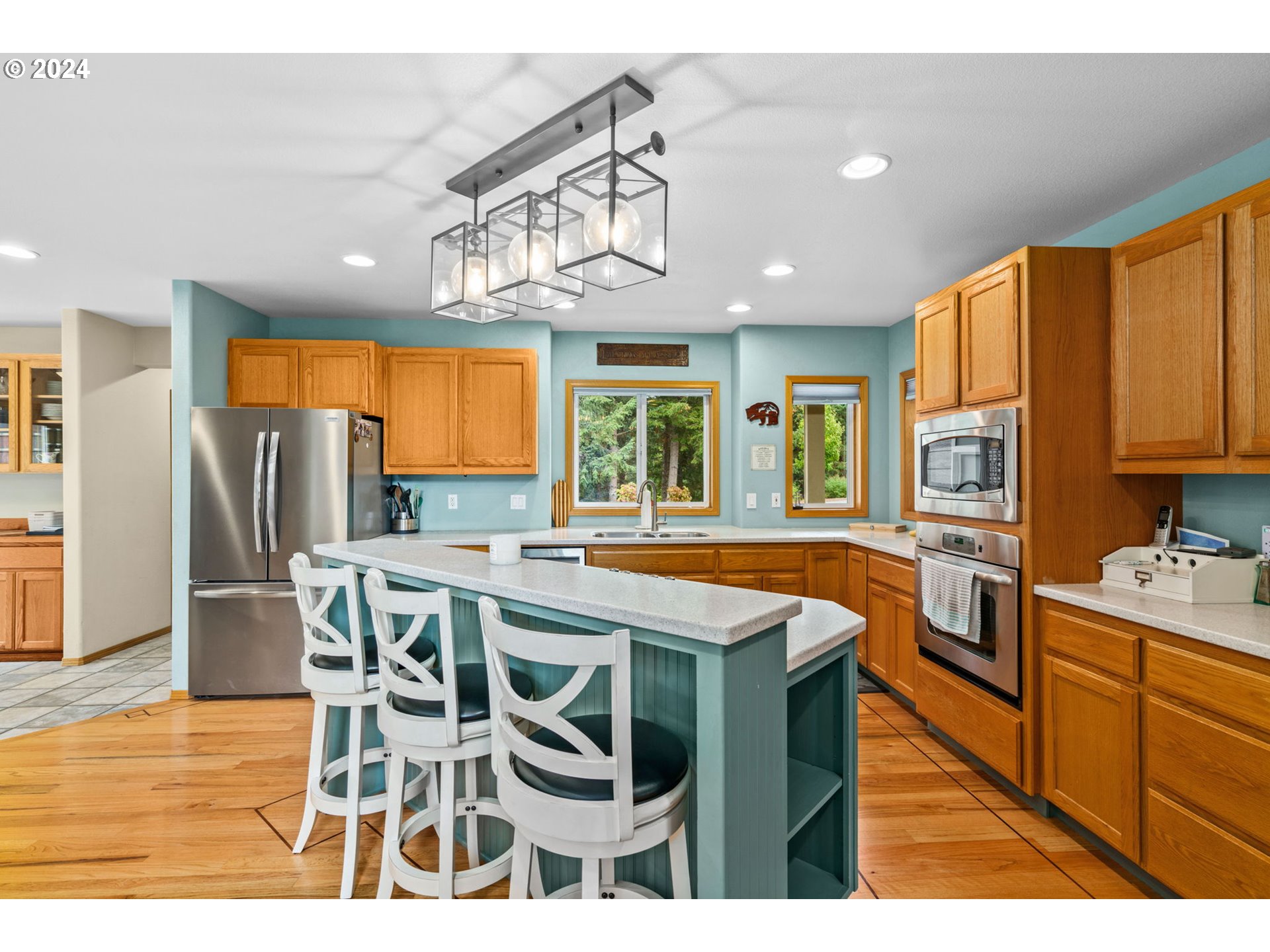 25241 Hall Road Cheshire, OR 97419 - Photo 5 of 48 a kitchen with stainless steel appliances kitchen island granite countertop a table chairs in it and wooden floors
