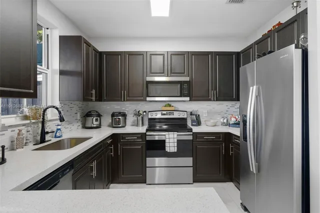a kitchen with stainless steel appliances a sink stove and cabinets