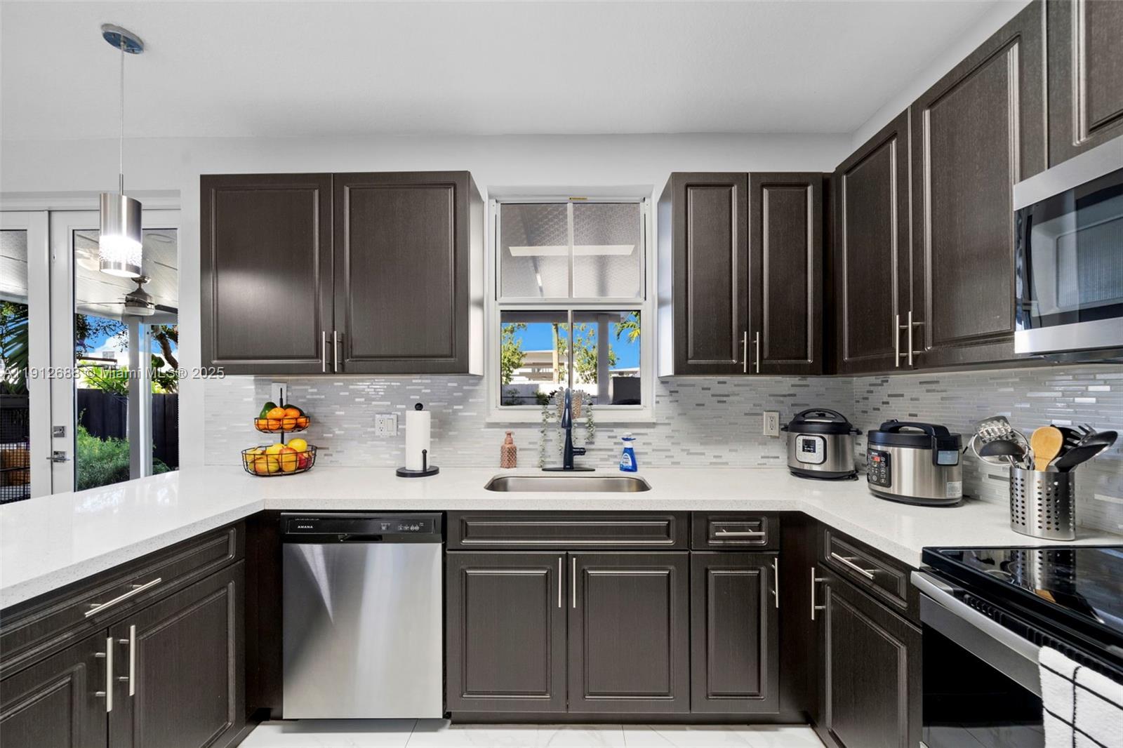 15245 Southwest 8th Way Miami, FL 33194 - Photo 12 of 25 a kitchen with stainless steel appliances a sink stove and cabinets