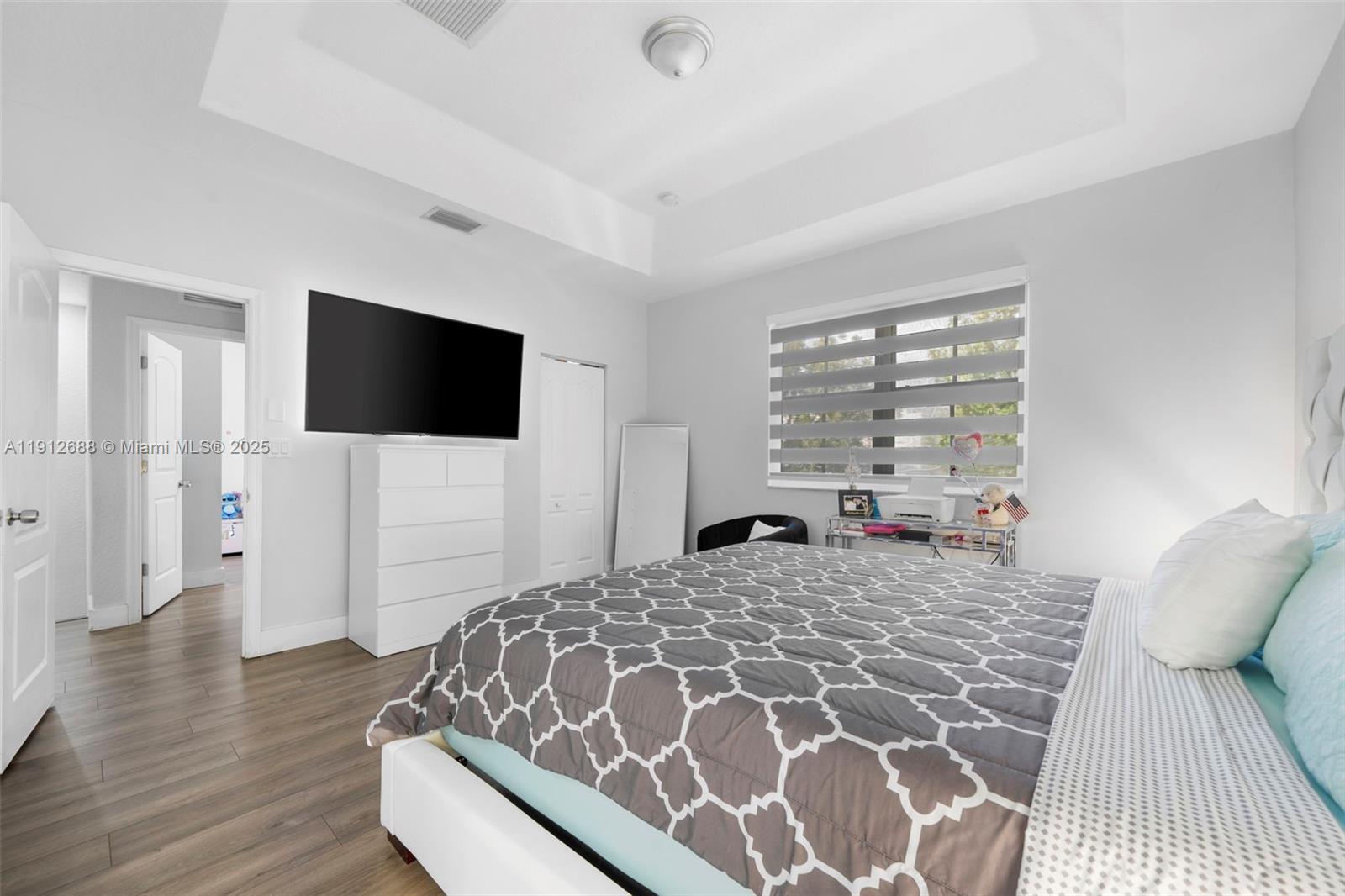 15245 Southwest 8th Way Miami, FL 33194 - Photo 17 of 25 a bedroom with a bed and a flat screen tv