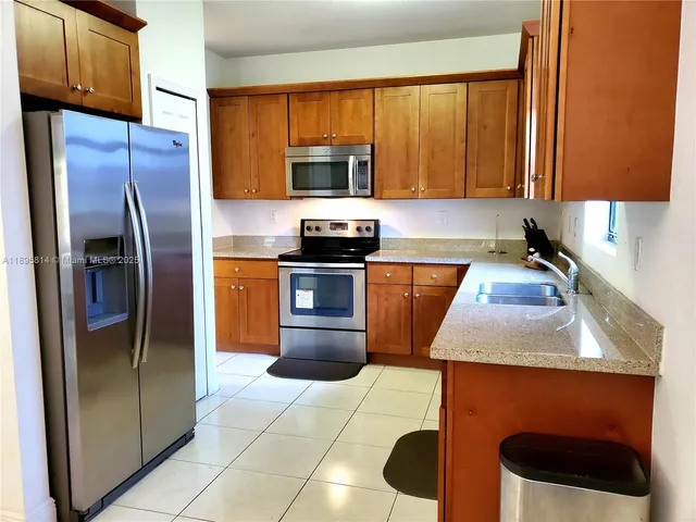 a kitchen with stainless steel appliances granite countertop a refrigerator a stove a sink and dishwasher