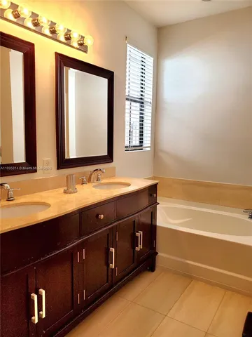 a bathroom with a double vanity sink and a bathtub