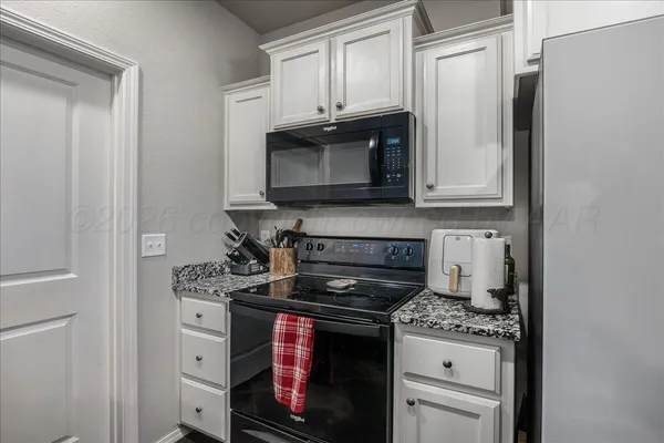 a kitchen with stainless steel appliances granite countertop a stove a microwave and a refrigerator