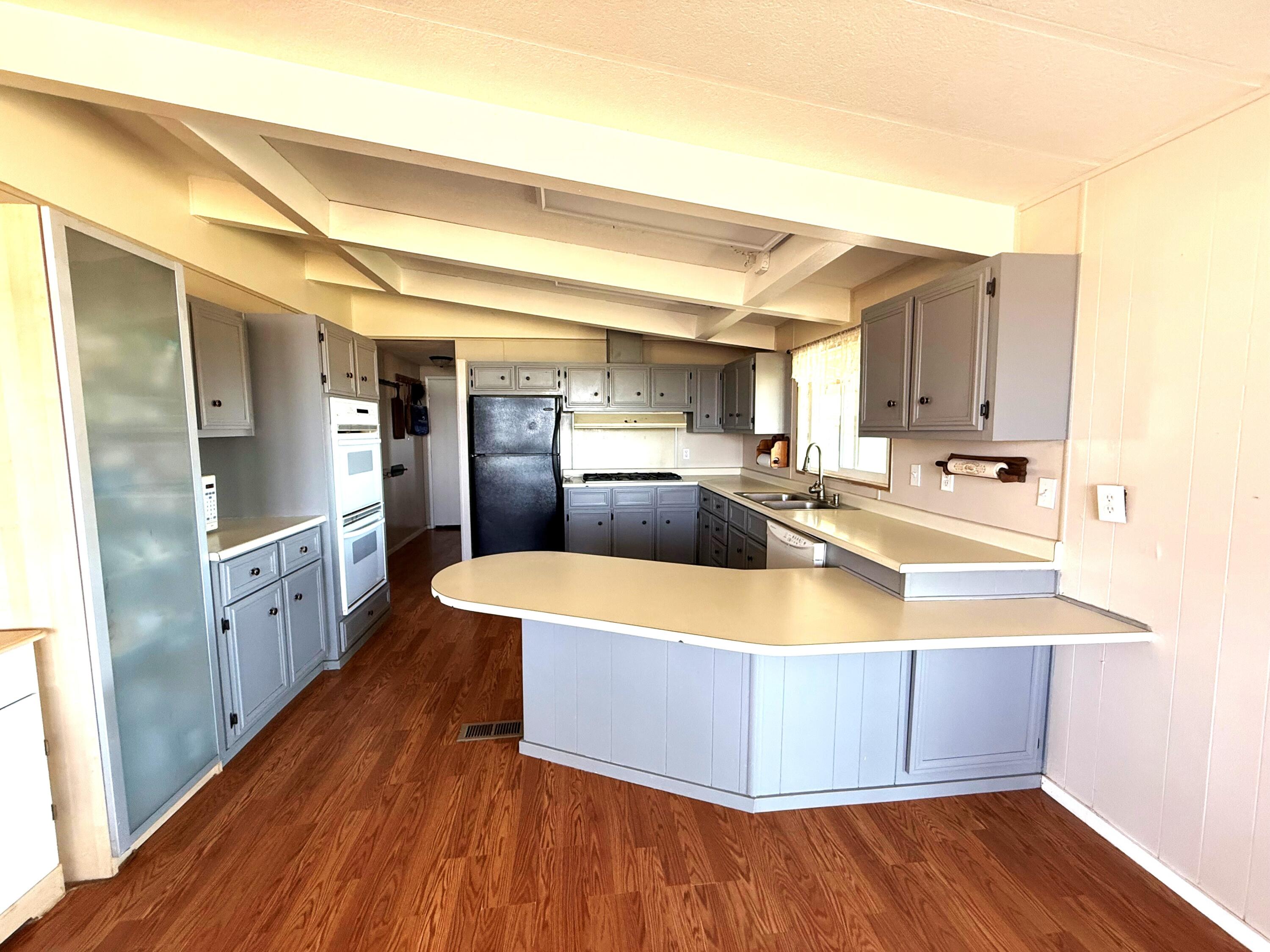 17550 Maupin Road Malin, OR 97632 - Photo 15 of 62 a kitchen with stainless steel appliances granite countertop a sink a refrigerator and wooden floor