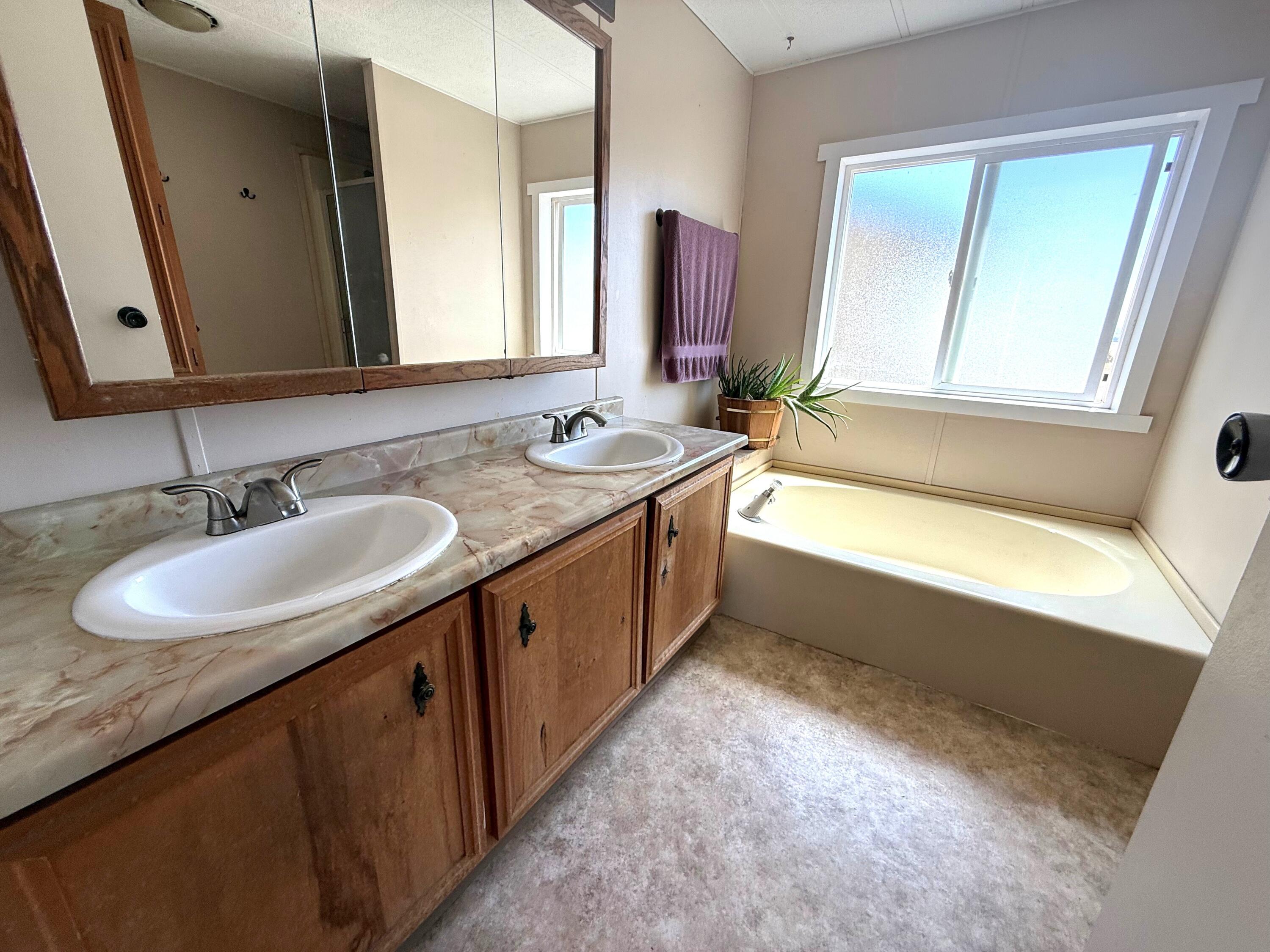 17550 Maupin Road Malin, OR 97632 - Photo 27 of 62 a bathroom with a double vanity sink and a bathtub