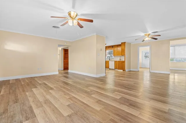 a view of an empty room with window and wooden floor