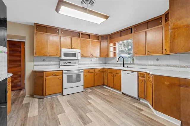 a kitchen with stainless steel appliances granite countertop a sink a stove and cabinets