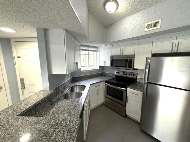 a kitchen with a refrigerator a microwave a sink and a stove