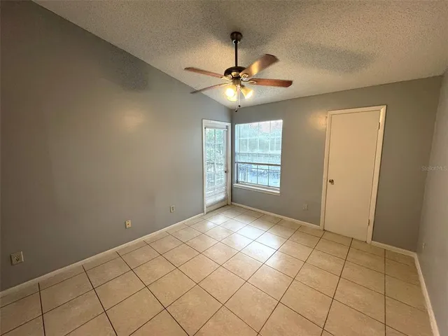 a view of an empty room and window chandelier fan