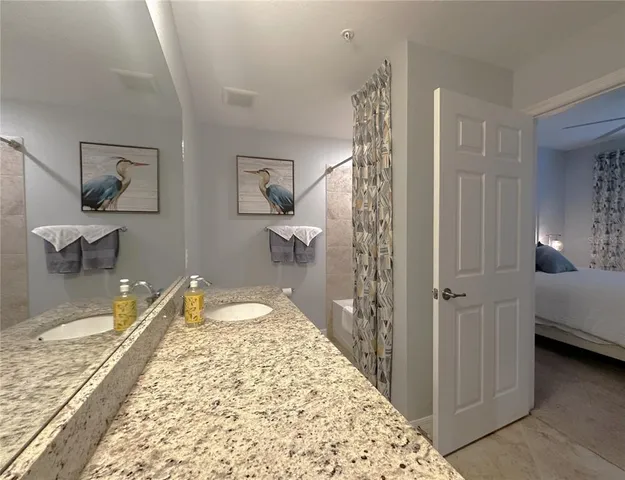 a spacious bedroom with a bed and a chandelier