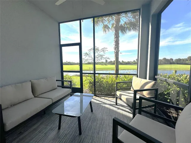 a living room with furniture and floor to ceiling windows