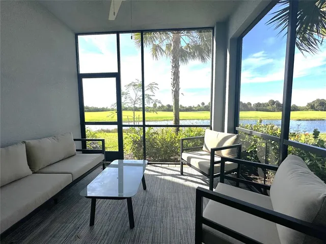 a living room with furniture and floor to ceiling windows