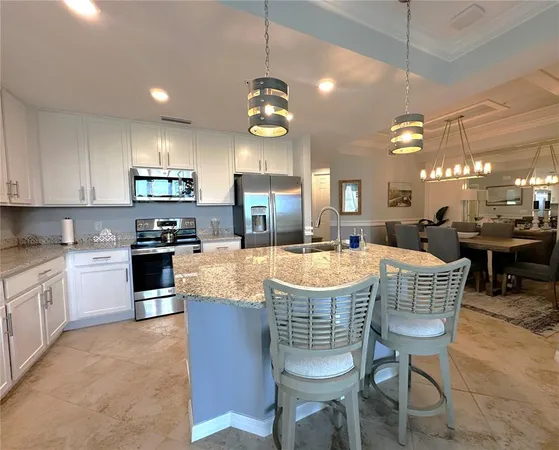 a kitchen with kitchen island a dining table and chairs