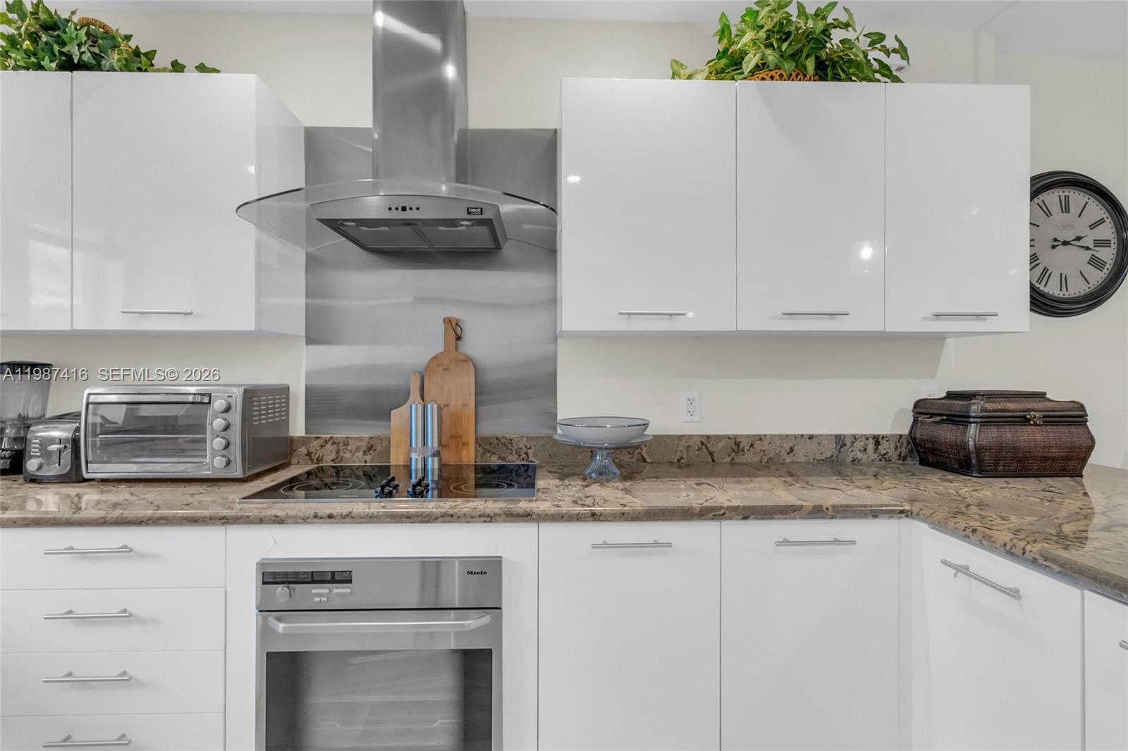 1995 Ixora Road North Miami, FL 33181 - Photo 14 of 30 a kitchen with granite countertop a sink and a stove
