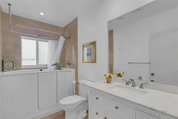 a bathroom with a granite countertop sink mirror and toilet