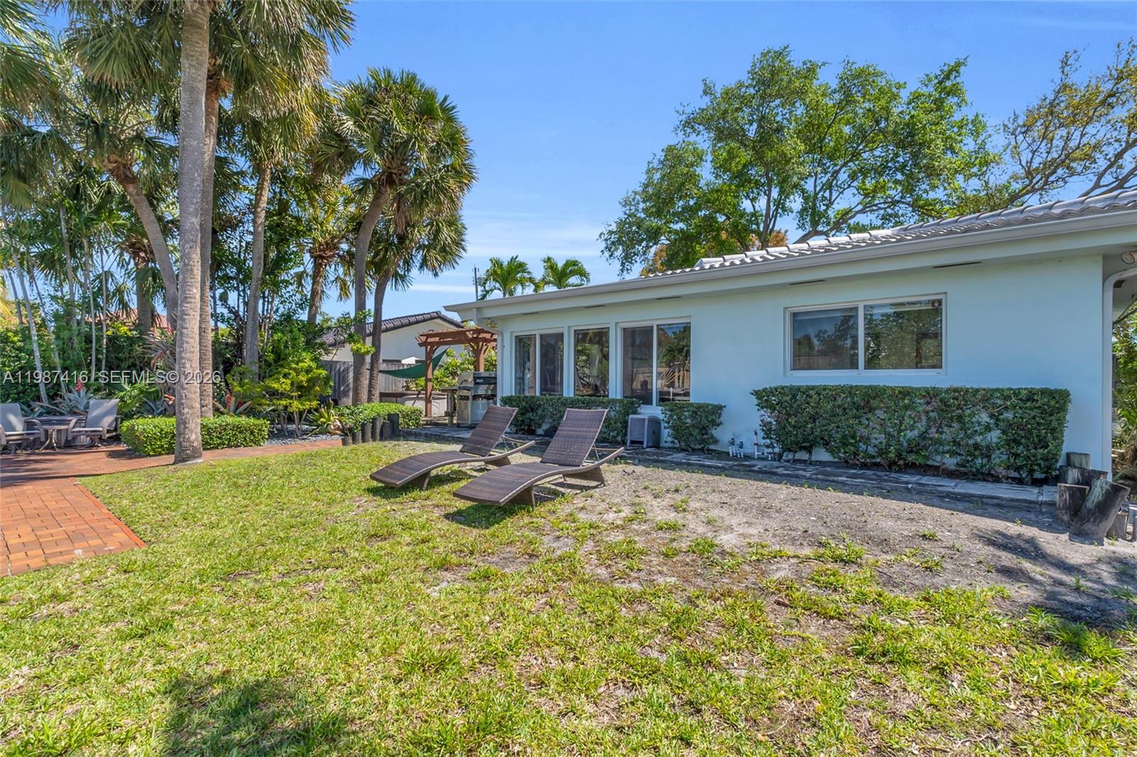1995 Ixora Road North Miami, FL 33181 - Photo 26 of 30 a view of a house with backyard sitting area and garden