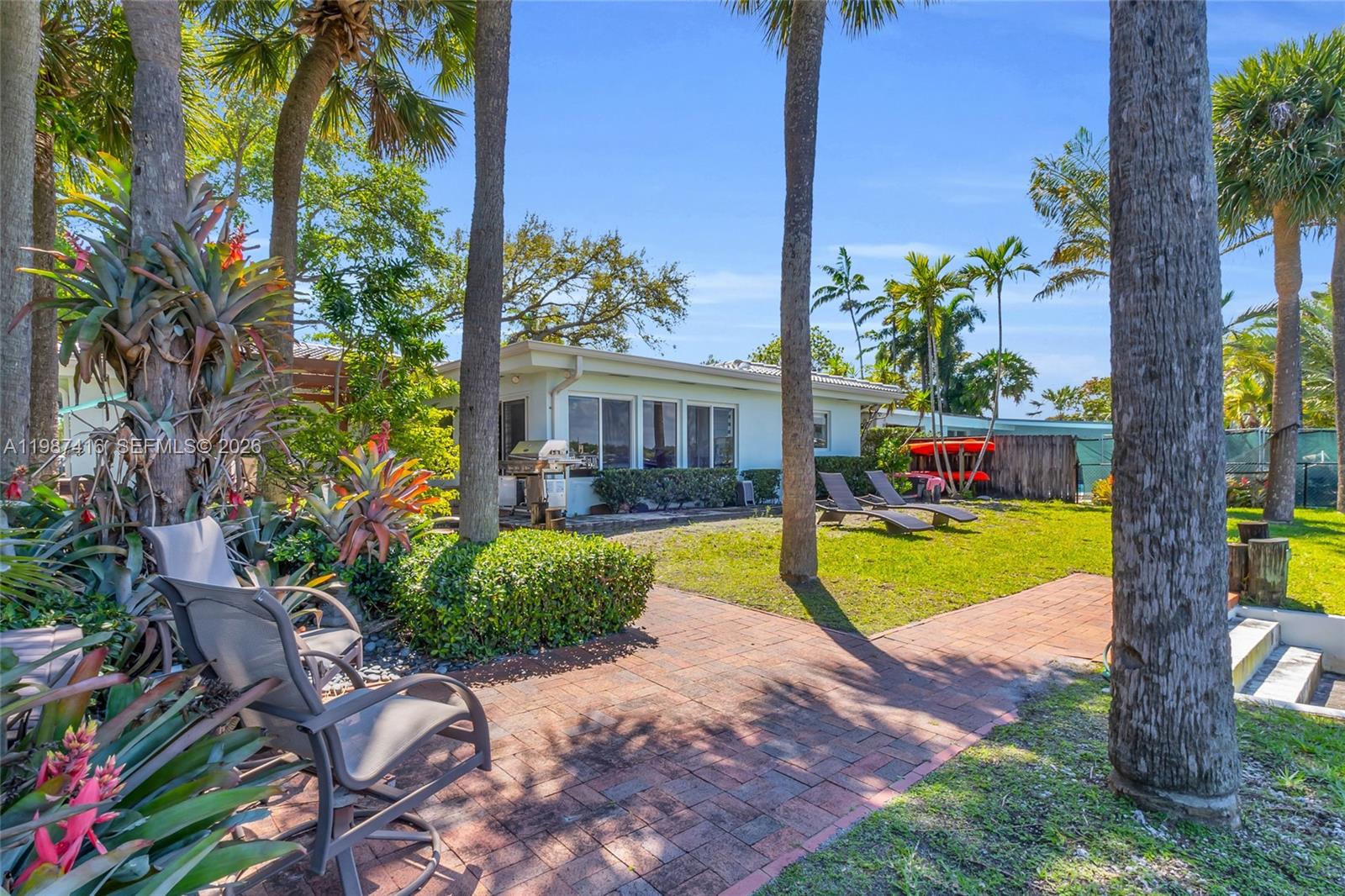 1995 Ixora Road North Miami, FL 33181 - Photo 27 of 30 a view of a house with swimming pool and next to a yard
