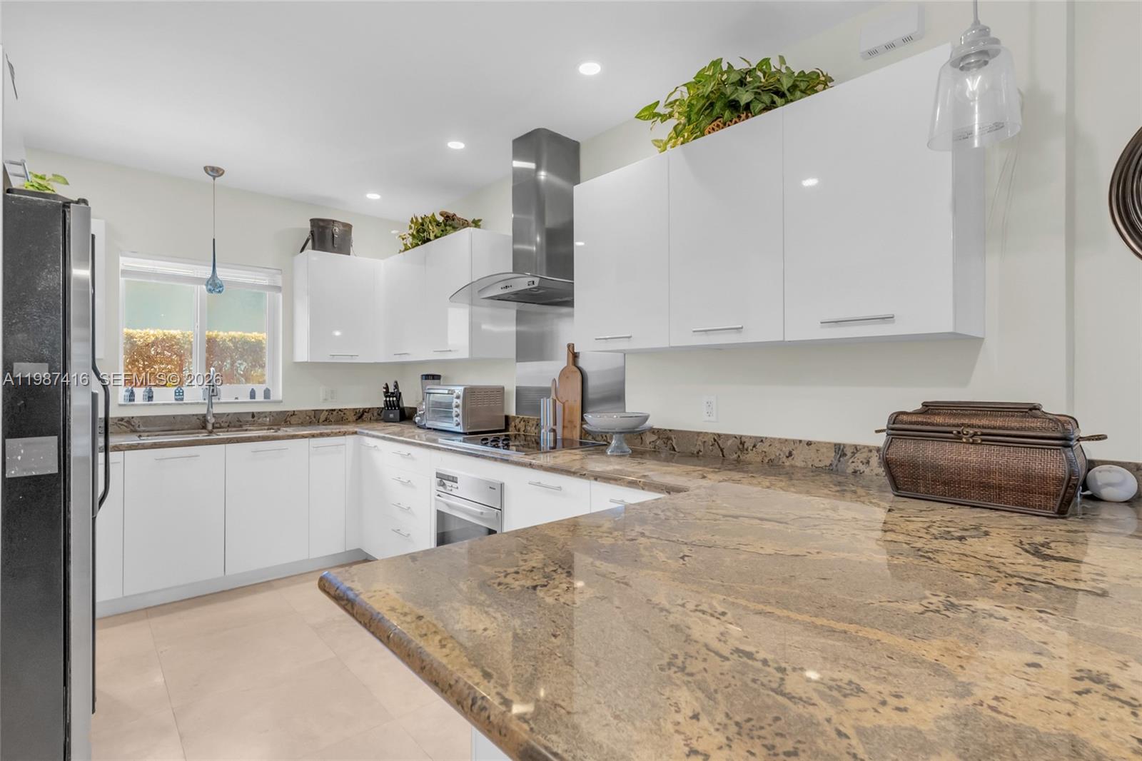 1995 Ixora Road North Miami, FL 33181 - Photo 3 of 30 a kitchen with a refrigerator and a stove top oven