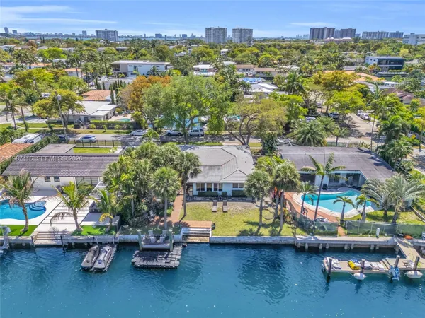 an aerial view of a house with a garden and lake view