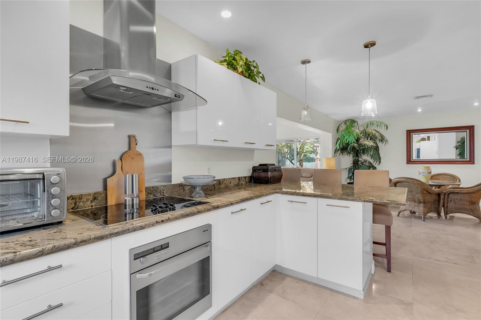 1995 Ixora Road North Miami, FL 33181 - Photo 7 of 30 a kitchen with stainless steel appliances granite countertop a sink a stove and a wooden floors