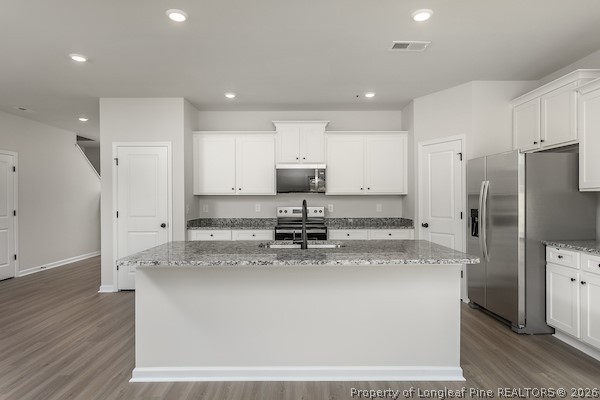 28 Rider Street Broadway, NC 27505 - Photo 12 of 22 a kitchen with stainless steel appliances granite countertop a sink a stove a refrigerator and a oven with wooden floor