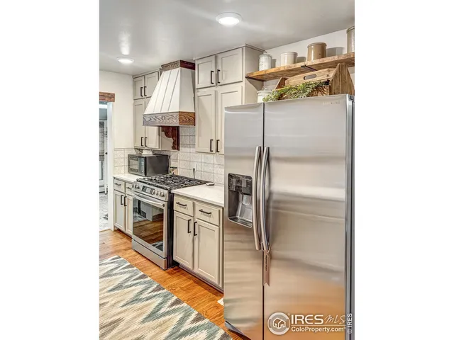 a kitchen with stainless steel appliances granite countertop a refrigerator and a stove