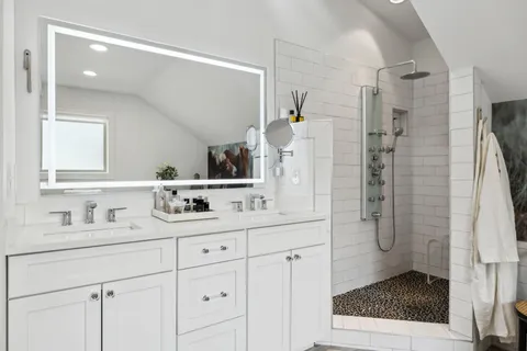 a bathroom with a shower sink and mirror