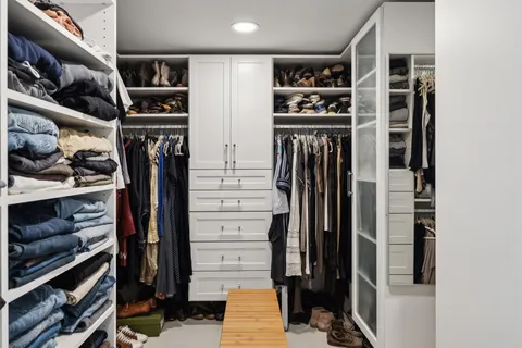 a view of walk in closet with clothes and shoes
