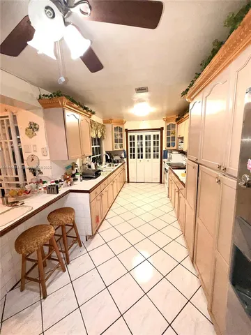 a large white kitchen with a sink a refrigerator and a stove