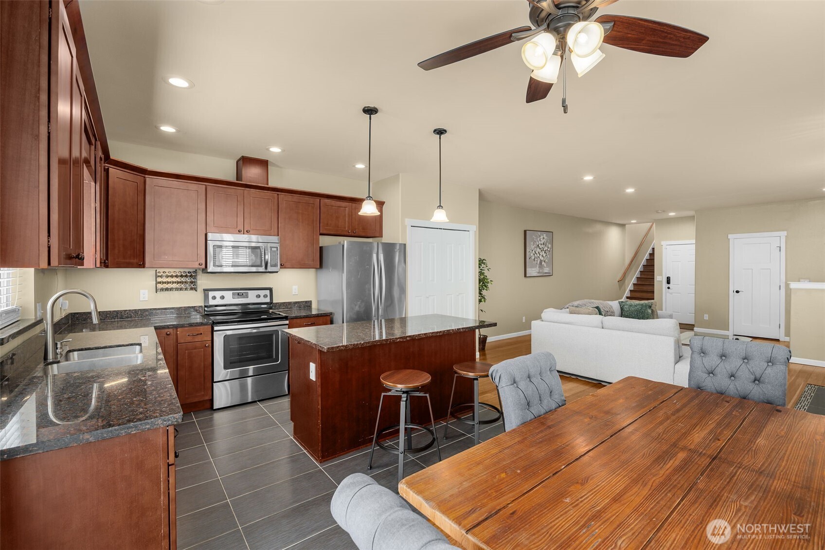 10250 17th Avenue Southwest Seattle, WA 98146 - Photo 5 of 23 a large kitchen with kitchen island a island a stove a sink a refrigerator and a dining table with wooden floor