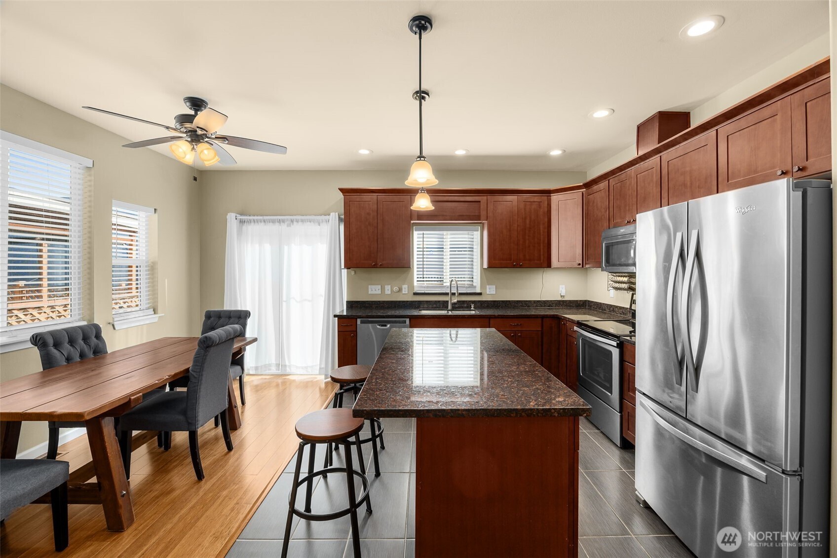 10250 17th Avenue Southwest Seattle, WA 98146 - Photo 7 of 23 a kitchen with kitchen island a dining table chairs stainless steel appliances and cabinets