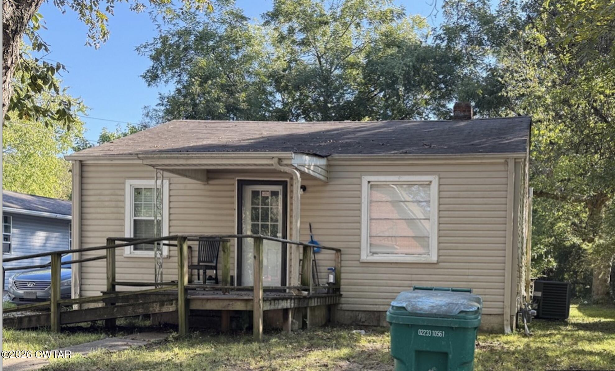 a backyard of a house with barbeque oven and trees
