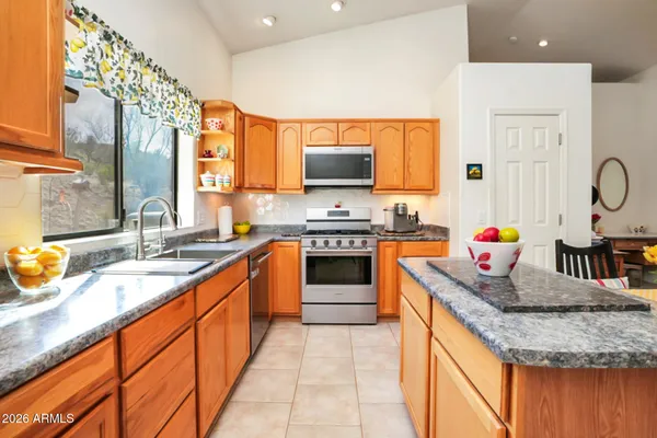 a kitchen with stainless steel appliances granite countertop a sink stove and cabinets