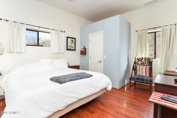 a bedroom with a bed and wooden floor