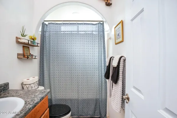 a bathroom with a granite countertop sink toilet and shower