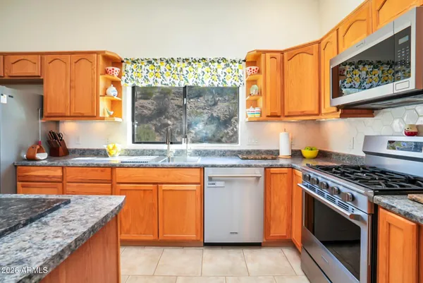 a kitchen with stainless steel appliances granite countertop a stove a sink and a microwave