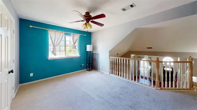 a view of an empty room with window and stairs