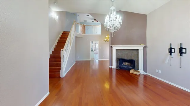a view of a livingroom with wooden floor and a fireplace