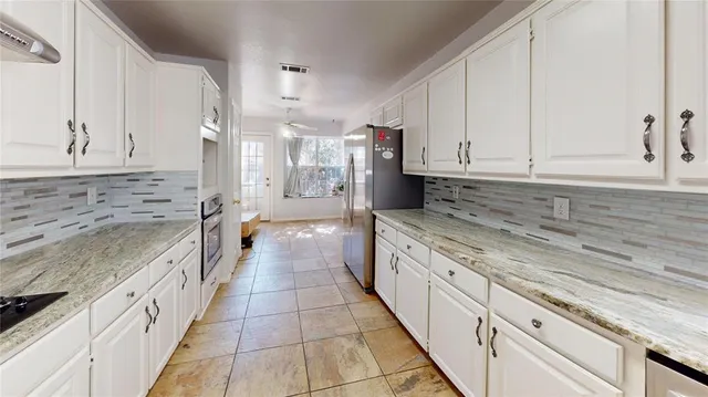 a large white kitchen with granite countertop a sink