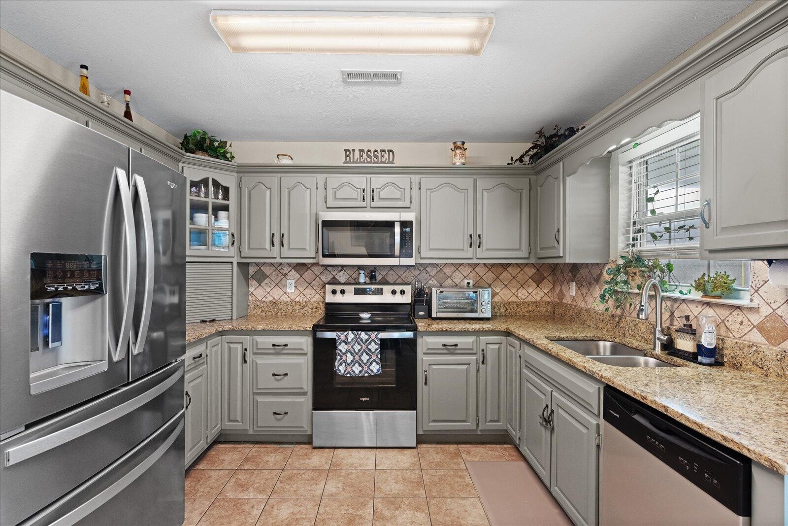 792 Colony Circle Fort Oglethorpe, GA 30742 - Photo 13 of 36 a kitchen with stainless steel appliances granite countertop a refrigerator sink and stove
