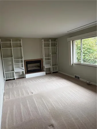 an empty room with a fireplace and windows