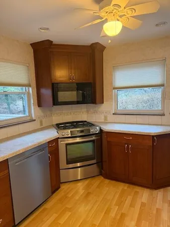 a kitchen with stainless steel appliances granite countertop a sink a stove and a microwave