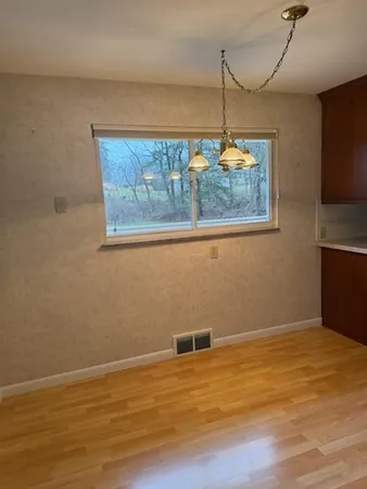 a view of a room with wooden floor chandelier and window